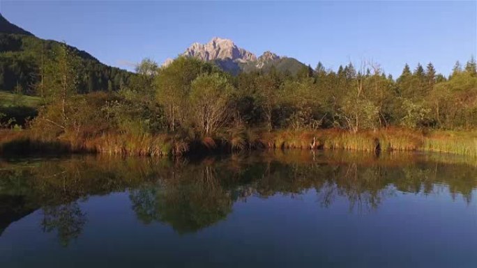 空中: 清晨的阳光照在令人惊叹的平静湖上，背景是云杉森林和落基山脉