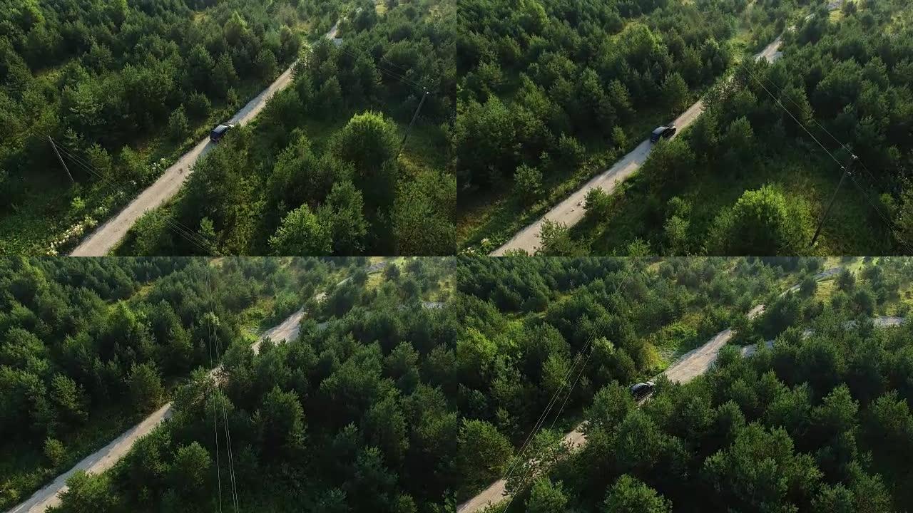 空中无人机在森林的道路上拍摄了一辆行驶中的suv汽车。