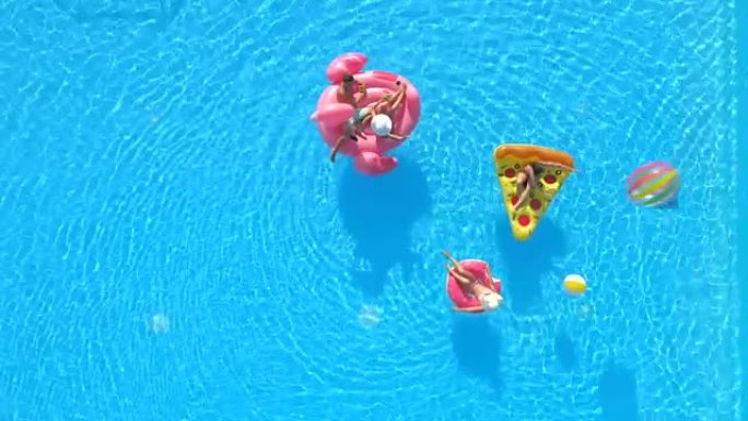 空中: 顽皮的朋友在充气披萨，甜甜圈和火烈鸟上玩得开心