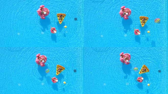 空中: 顽皮的朋友在充气披萨，甜甜圈和火烈鸟上玩得开心