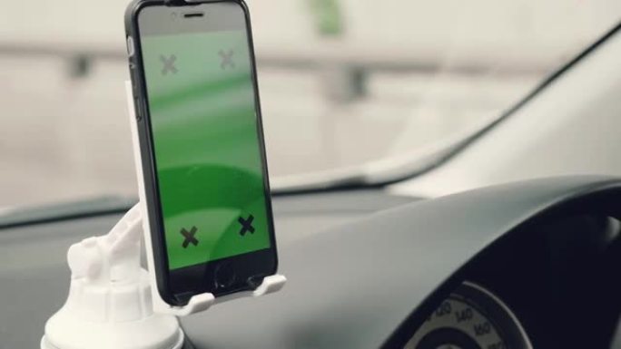 在汽车上使用智能手机的人的特写镜头，绿屏