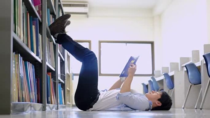 年轻人躺着看书。躺在图书馆里。