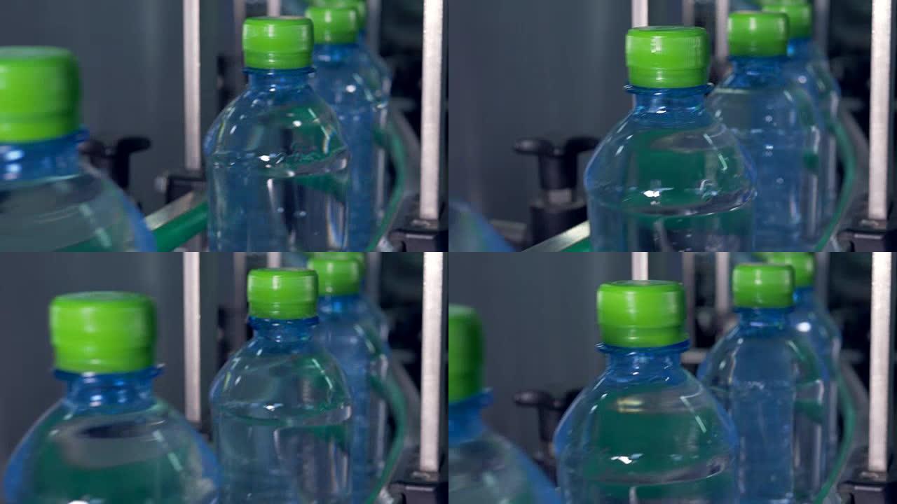 传送带上有绿色瓶盖的水瓶。4K。