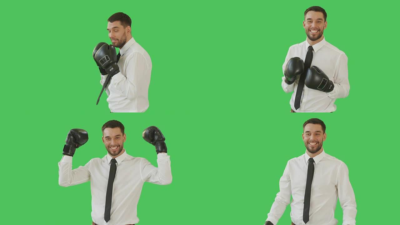 一个穿着衬衫和领带的英俊男子的中枪，穿着拳击手套进行淘汰赛，以获胜的姿态举起双手。背景是绿色屏幕。