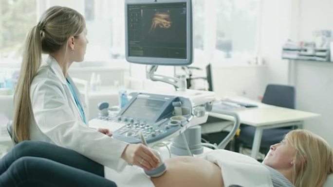 在医院，孕妇接受超声/超声扫描，产科医生向她和她的支持丈夫解释程序。幸福的家庭等待他们的第一个孩子。