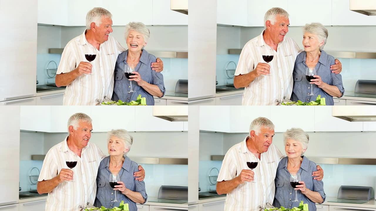 高级夫妇一边喝红酒一边准备健康沙拉