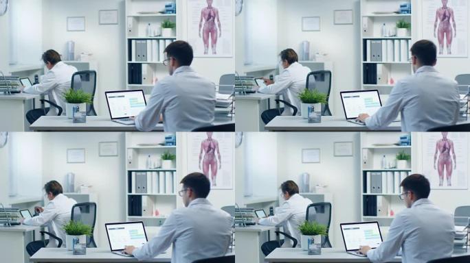 男医生在笔记本电脑上读取患者的医疗卡并进行更正，他的助手在后台工作。办公室现代、宽敞、轻便。