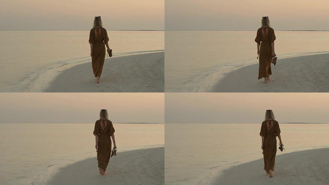 在海滩上散步的漂亮女人的镜头。平静的海面和柔和的清晨，傍晚的色彩。