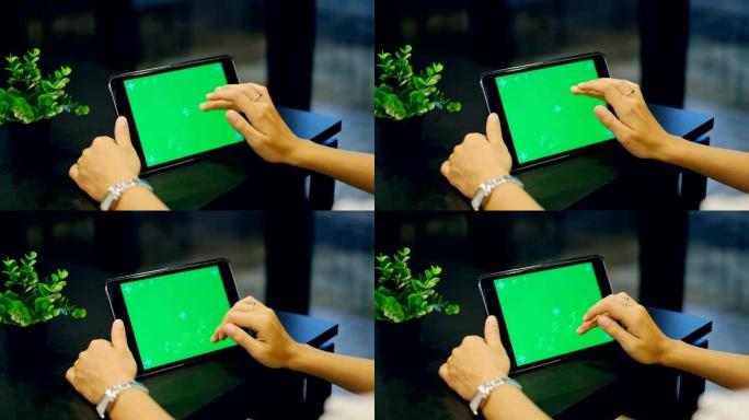 亚洲女性晚上使用绿屏平板电脑