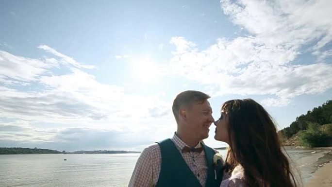 男人和女人，年轻幸福的已婚夫妇剪影在岸上接吻