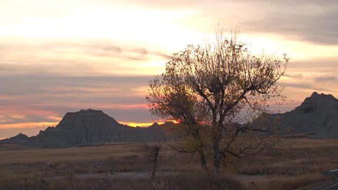 近距离观察在Badlands日落时，令人惊叹的砂岩山在干燥的草原上升起