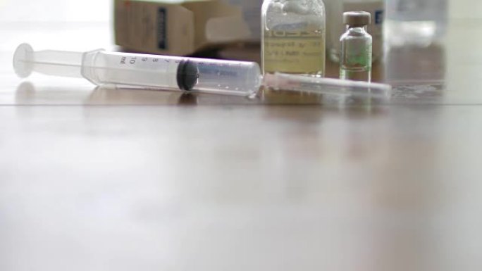 注射疫苗注射器与小瓶医疗特写在白色背景和木桌