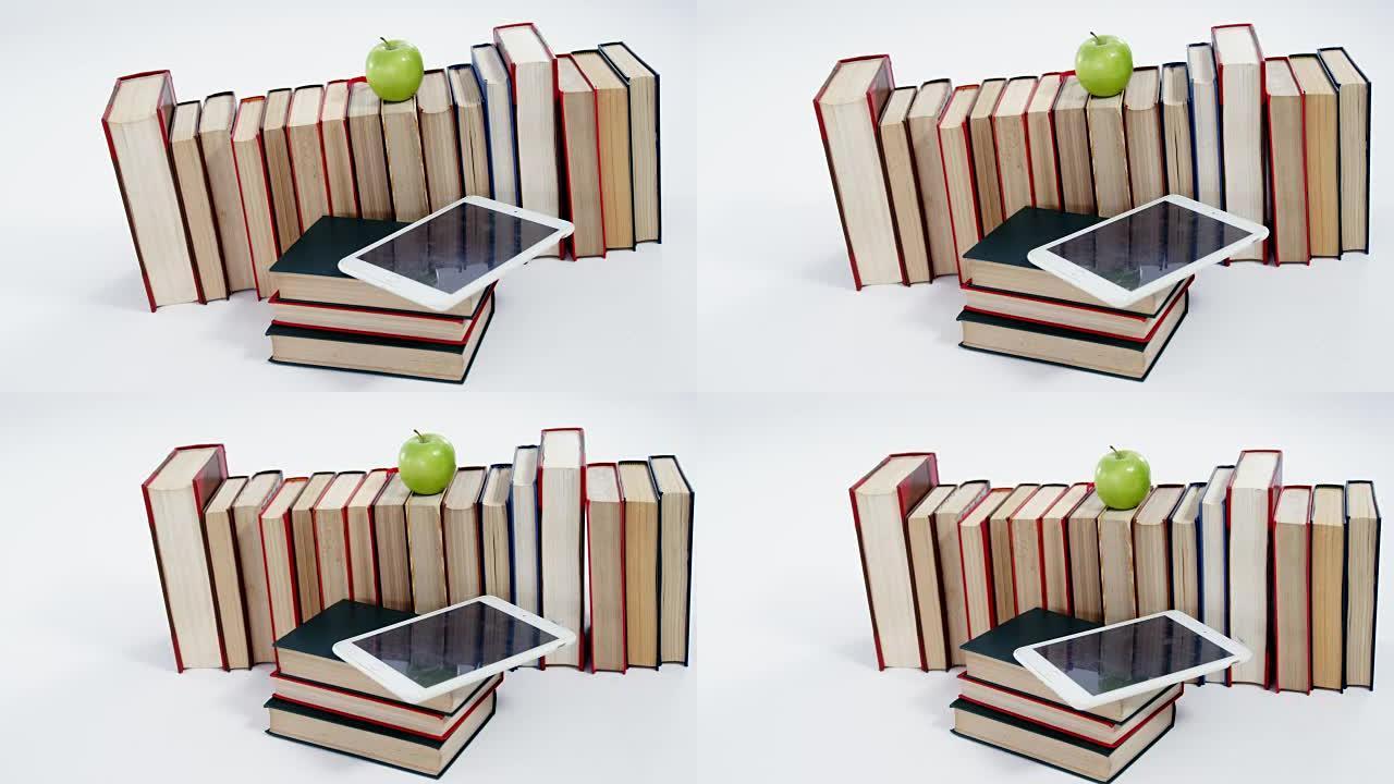 苹果，数字平板电脑和白色背景上的书籍