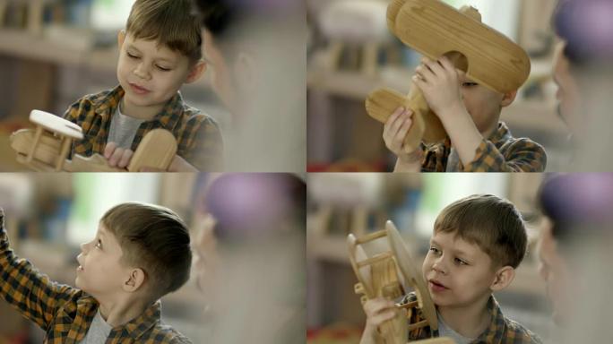 可爱的男孩玩木制飞机玩具