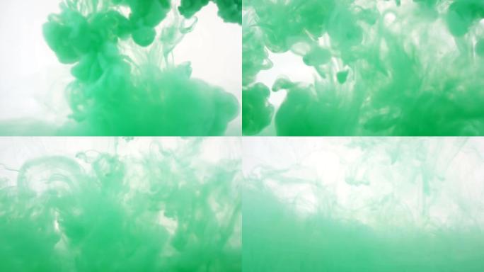 彩色背景。绿色墨水掉进了水里。慢动作