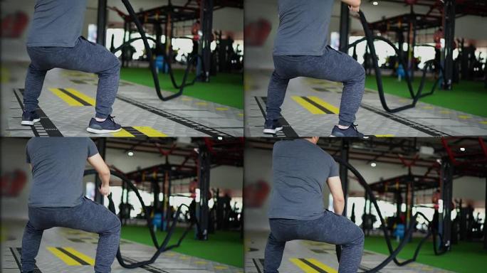 慢动作男子在健身房做战斗绳运动