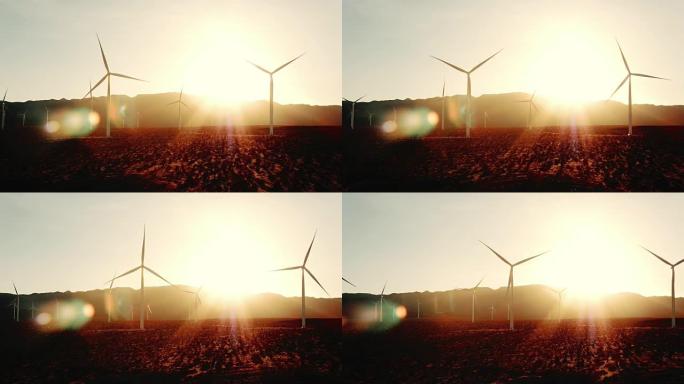 风车风力涡轮机在日落时在沙漠中旋转，镜头耀斑创造清洁能源