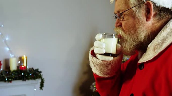 圣诞老人在椅子上放松，喝牛奶