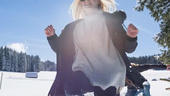 年轻女性在冬季景观中互相追逐