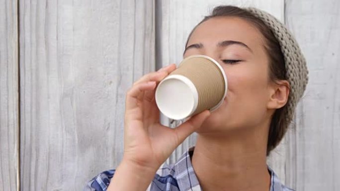 年轻女子用一次性杯子喝咖啡