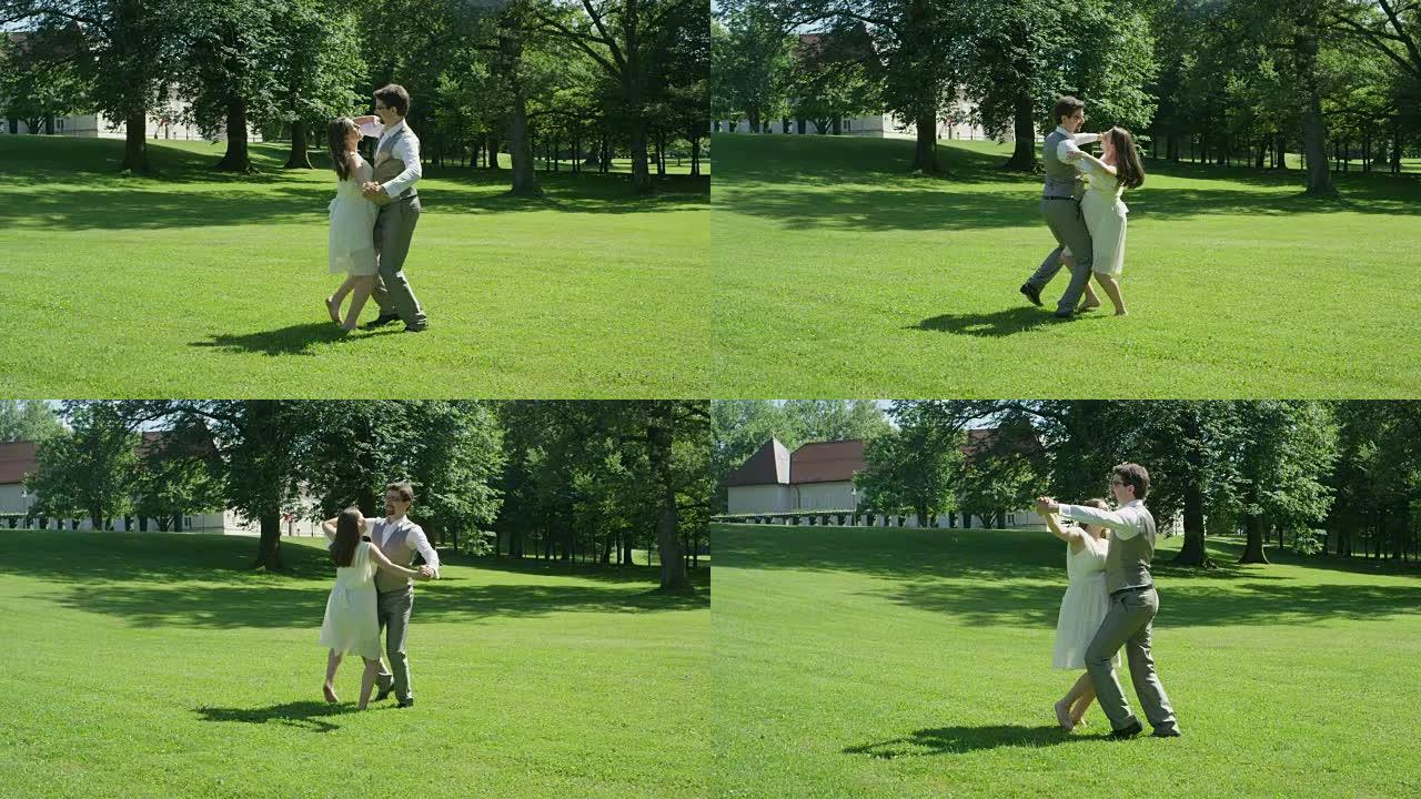 慢动作年轻新婚夫妇在温暖的晴天在绿色公园的草地上漫步
