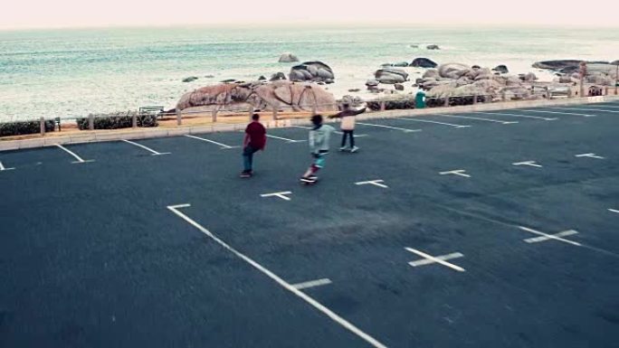 非裔美国人在海边停车场玩滑板
