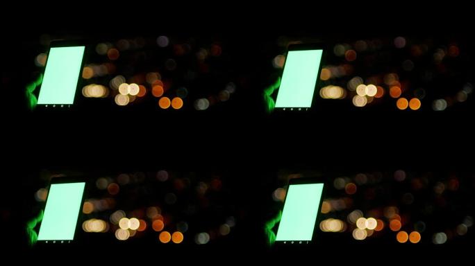绿屏智能手机和城市的bokeh circle灯光背景