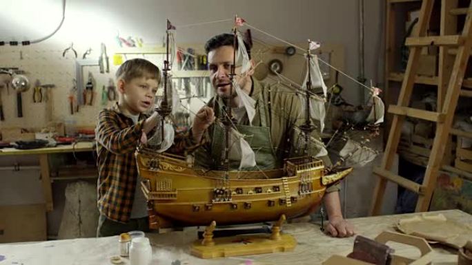 男孩和父亲一起研究船模