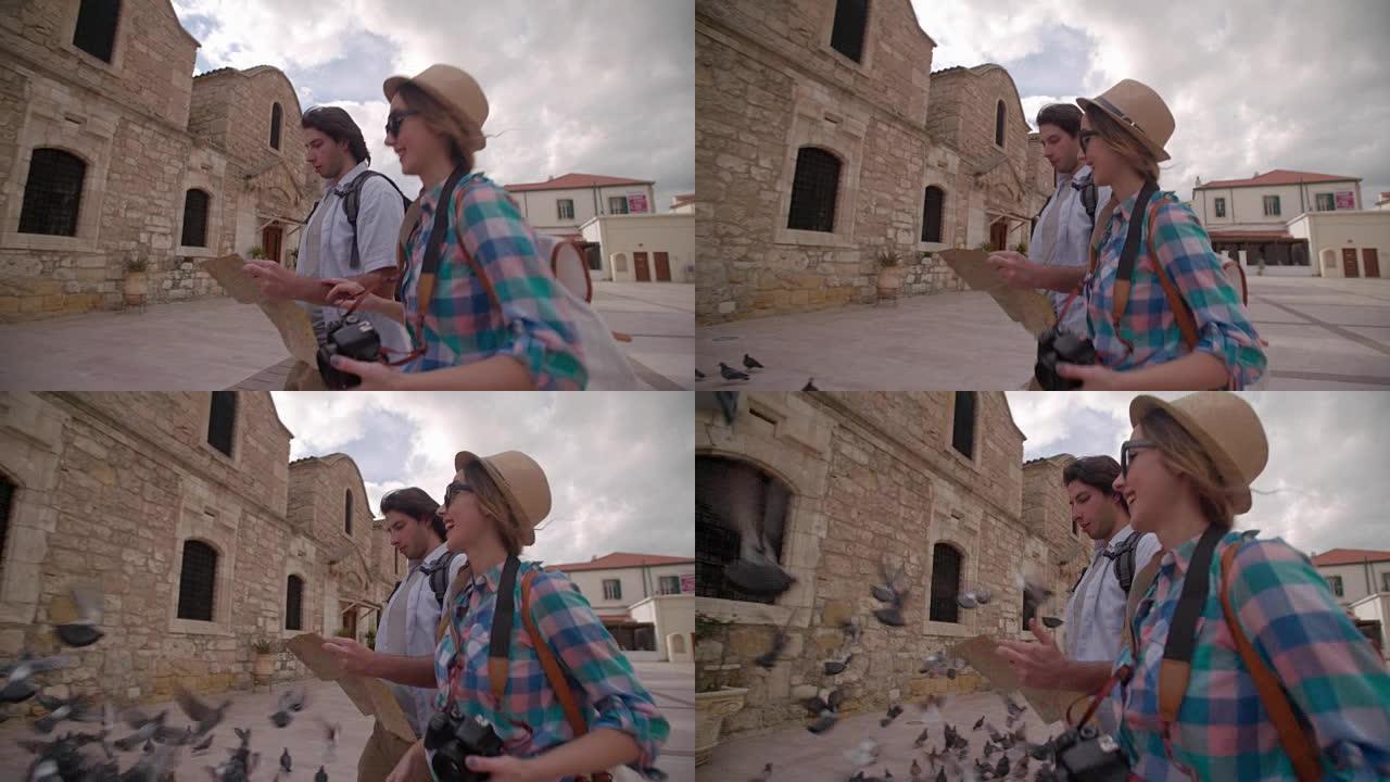 年轻夫妇带着地图在古老的石头建造的村庄里走来走去