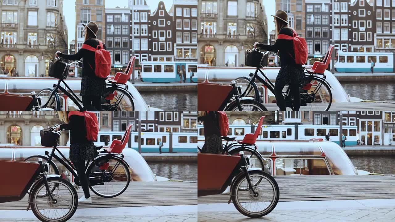 旅游小姐骑自行车去城市河码头。高加索女性站着，骑自行车神奇的老城。慢动作