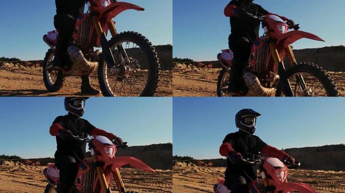 低角度镜头的职业摩托车越野赛骑手在FMX摩托车站在采石场中间，俯瞰极端越野地形，他今天要骑。