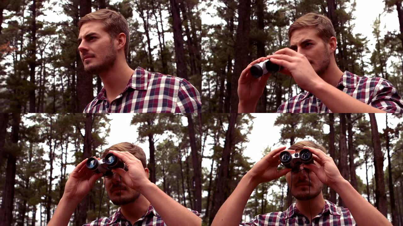 男人用双筒望远镜徒步穿越森林