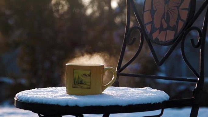 在白雪覆盖的椅子上喝杯热茶