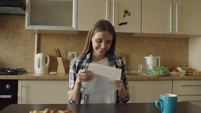 有魅力的幸福女人一大早在家吃早饭时在厨房里收到喜讯读信