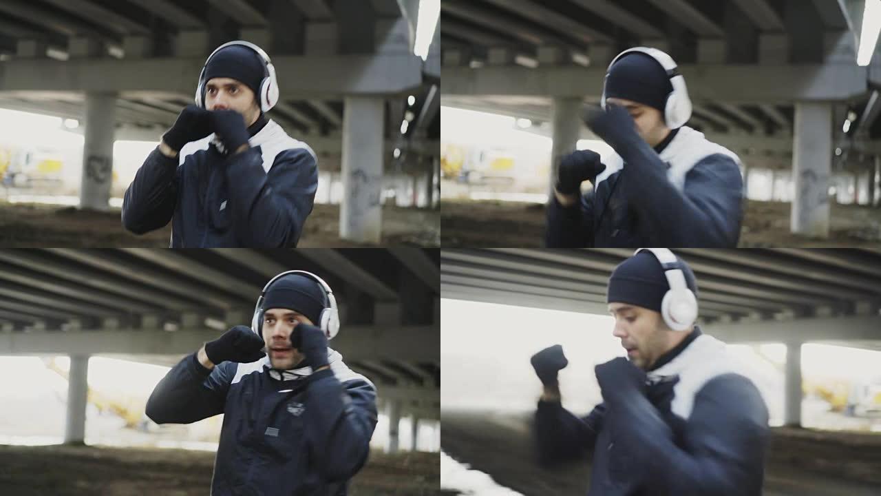 多莉拍摄的运动男拳击手戴着耳机训练拳击冬季户外城市位置
