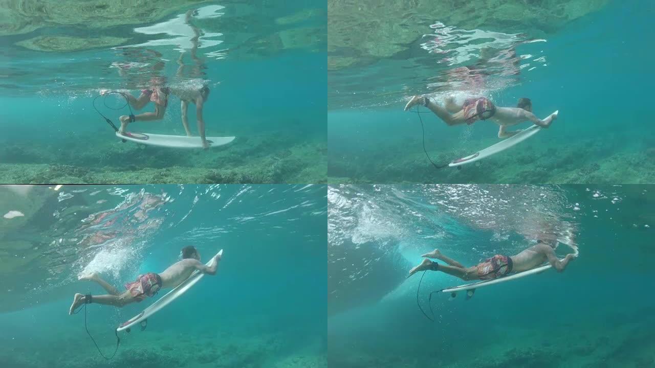 慢动作: 极端冲浪者在海浪下潜水。