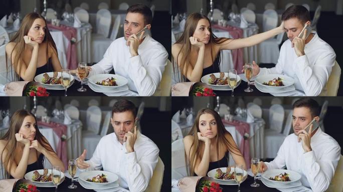 忙碌的年轻人正在用手机聊天，而他的女友坐在餐厅的餐桌旁感到无聊。现代技术、关系和无聊概念。
