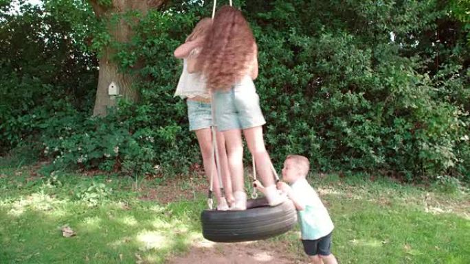 一群在花园里玩轮胎秋千的孩子