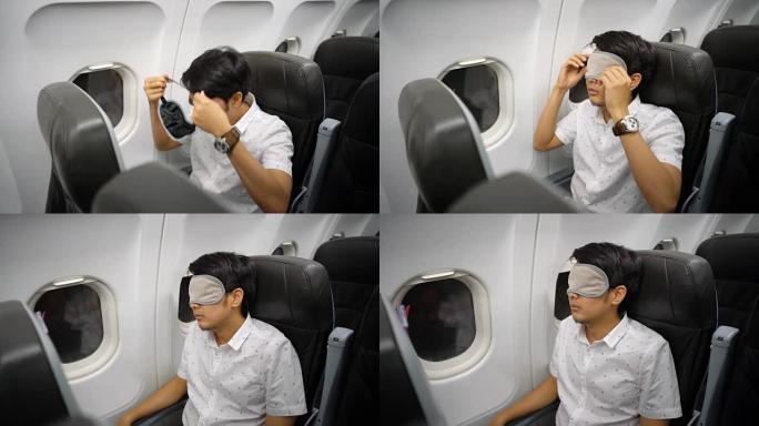 男子戴着眼罩睡眠面罩在飞机上睡觉