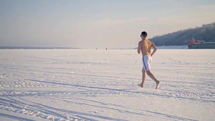 一个健康的人赤脚在雪地上跑步。