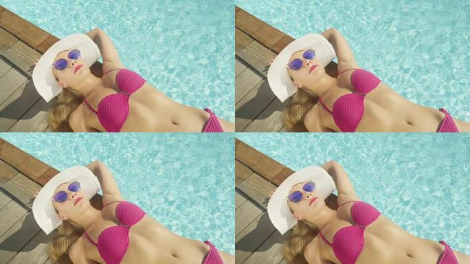 特写: 在翡翠游泳池旁放松的暑假日光浴时，适合女性。