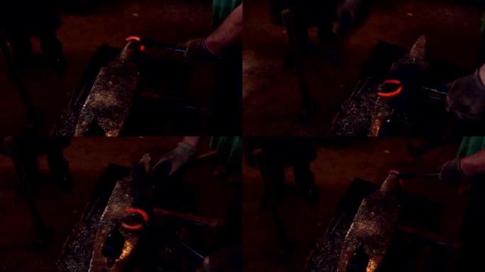一个铁匠在车间用铁锤在铁砧上锻造马蹄铁。用热红色金属工作的人