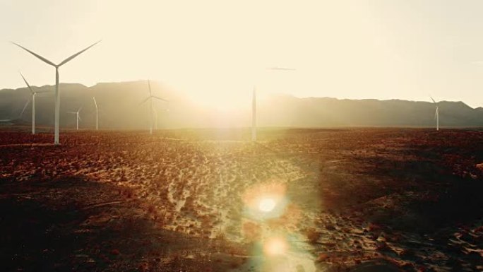 日落时沙漠中风车的鸟瞰图，镜头耀斑