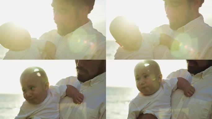 年轻的爸爸在日落时以慢动作抱着男婴