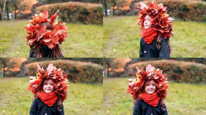 女孩回去，然后转身看着相机。可爱的小女孩戴着秋天枫叶的花环皇冠