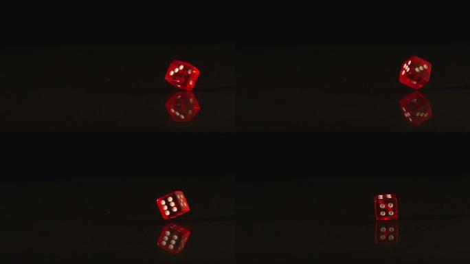 黑色背景上旋转的红色塑料骰子