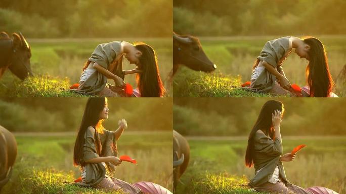 美丽的亚洲女人的肖像在傍晚坐在田野上，夕阳温暖。