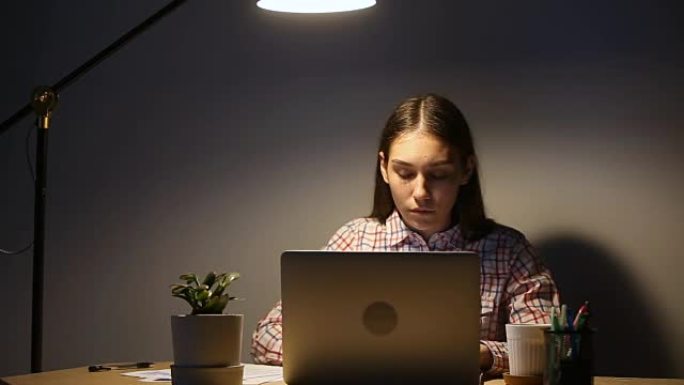 年轻专注的女人使用笔记本电脑加班到很晚