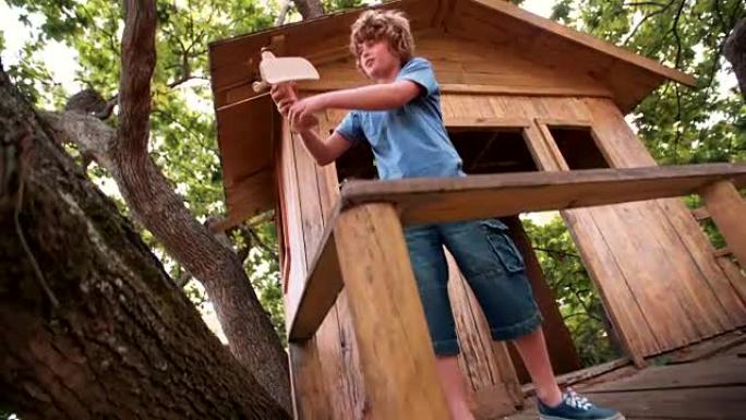 在树屋里的男孩用他的玩具木制飞机做白日梦