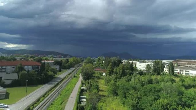 田园诗般的郊区城镇，当地街道和铁路上方的空中黑暗暴风雨云